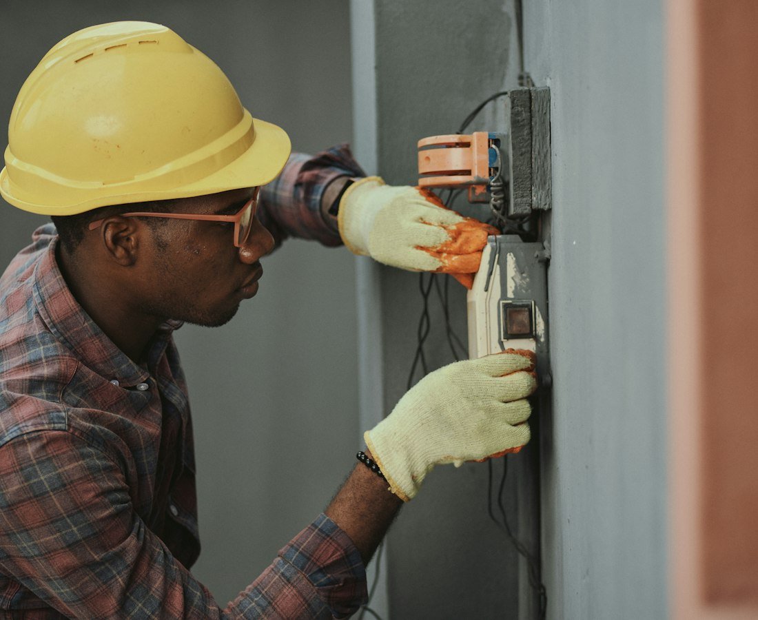 Electrician installing wiring at a switch board
